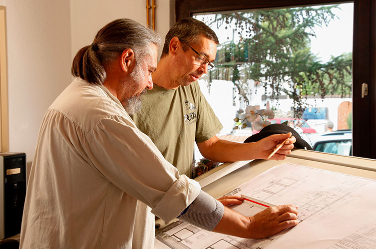 immerermeister Thorsten Raab und sein Mitarbeiter vor einem Bauplan für die Sanierung eines Fachwerkhauses
