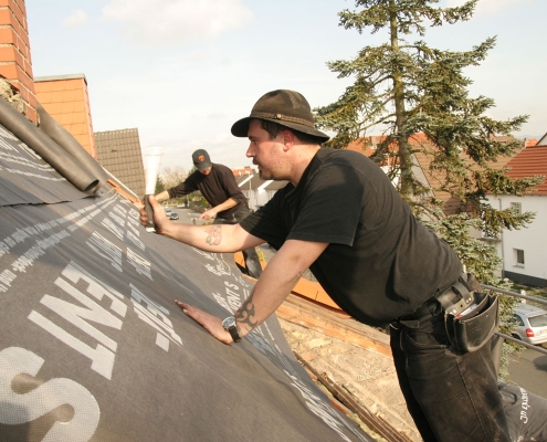 Dachdecker auf dem Dach während einer Dachumdeckung