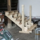 vormontierte, aufgesattelte Treppe zur Veranda mit geschnitzten Pfosten als Rohbau in der Werkstatt