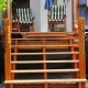 Treppe vom Garten zur Veranda aus lasiertem Holz mit Schnitzdetails